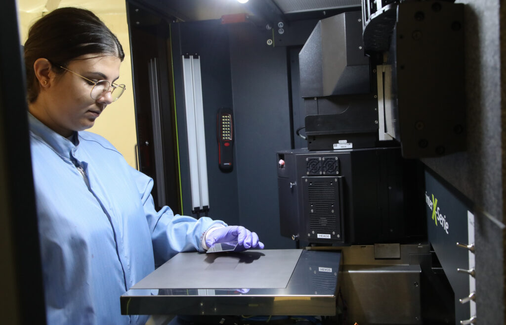 Technicienne OPV chez Dracula Technologies imprimant des modules photovoltaïques organiques sur une machine industrielle (c) Dracula Technologies